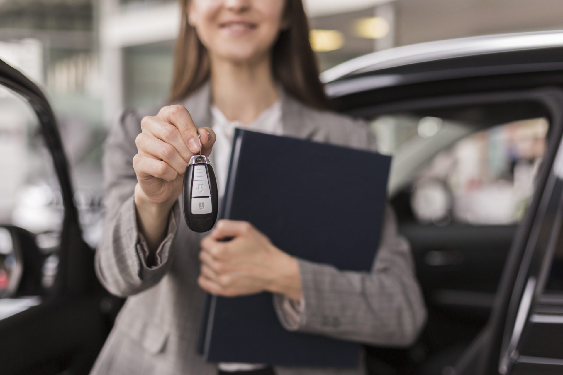 Female hands holding folder car keys scaled 1
